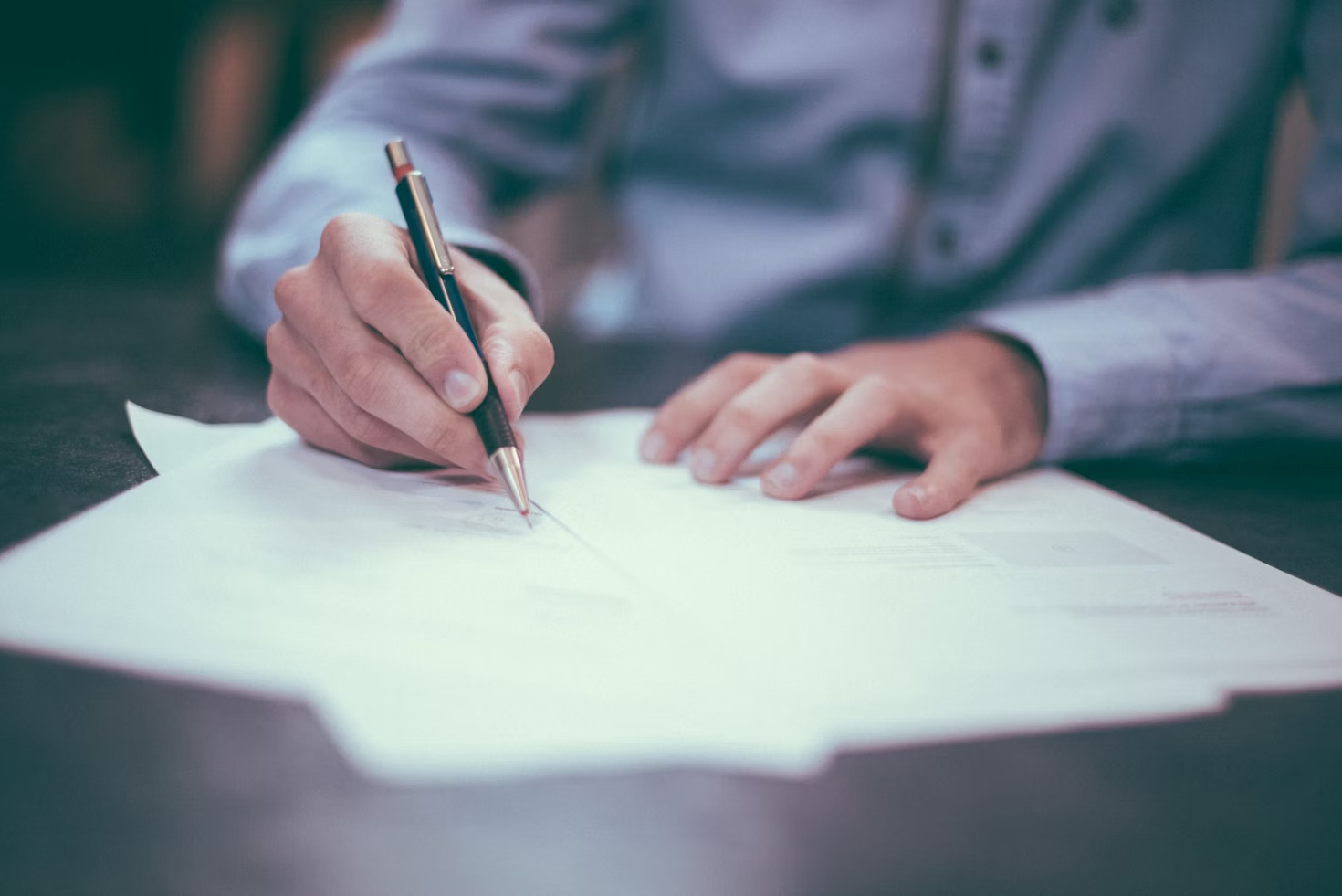 Escribano firmando documentos legales - Servicios profesionales de Escribanía Kiss